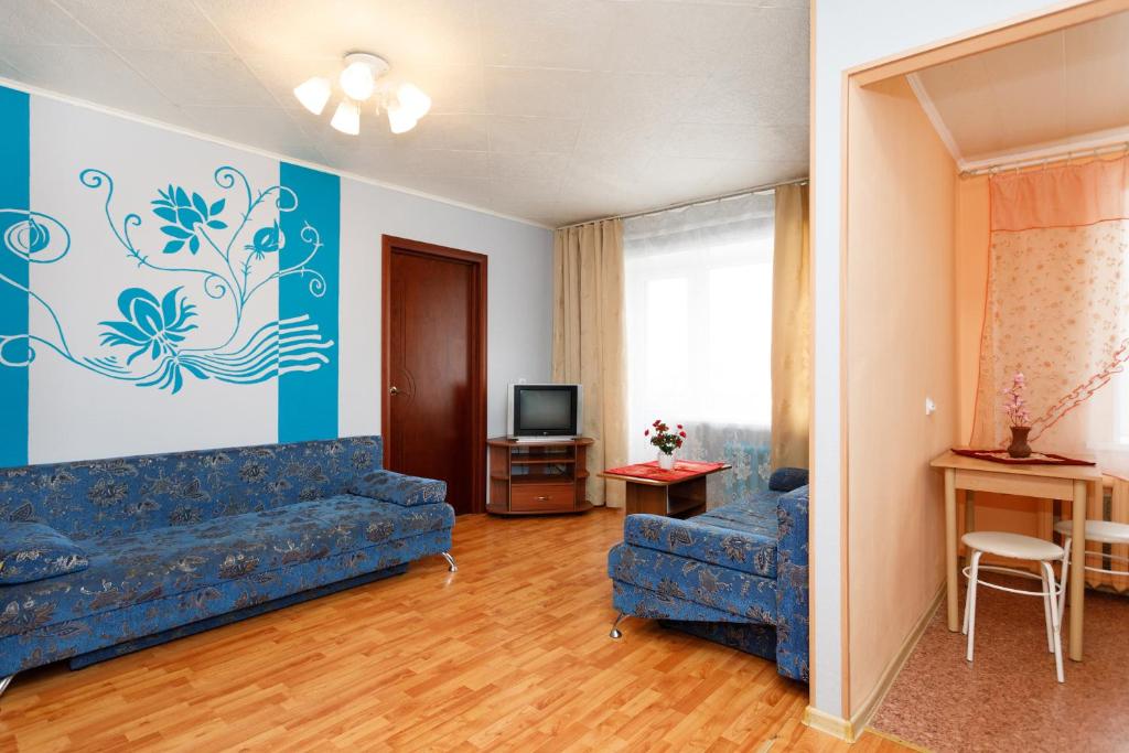 a living room with a couch and a tv at Apartments on Chelyuskintsev in Yekaterinburg
