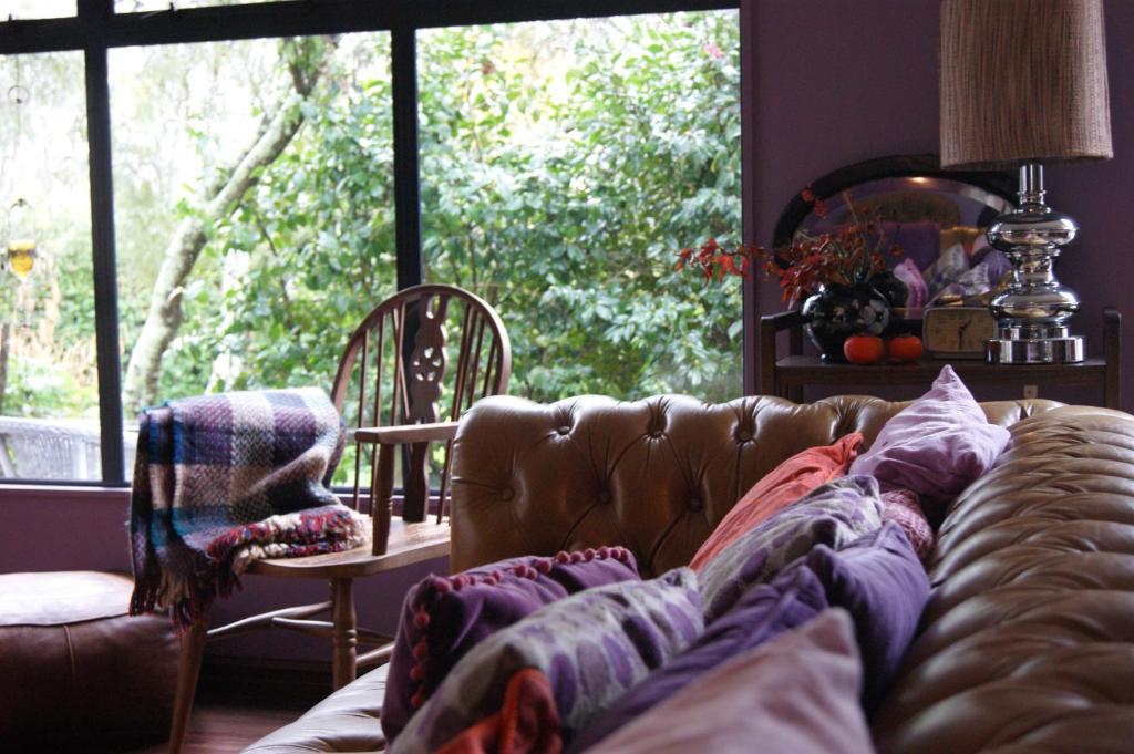 a living room with a couch and a large window at Waitapu Springs B&B in Takaka