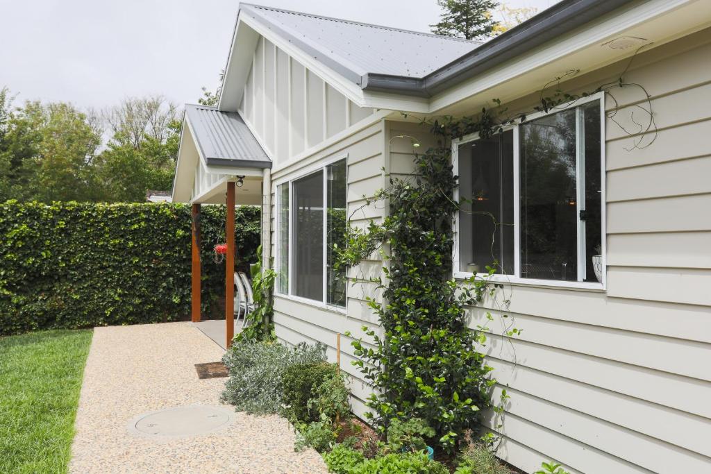 a white house with a window and ivy at Armidale Cottage - House 2 in Armidale