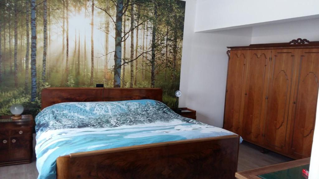 - une chambre avec un lit et une peinture d'arbres dans l'établissement Twins Farm, à Cormòns