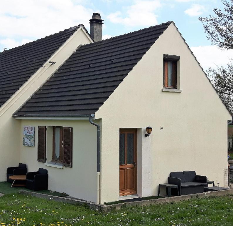 ein weißes Haus mit schwarzem Dach in der Unterkunft Le Mouton Blanc in Couloisy