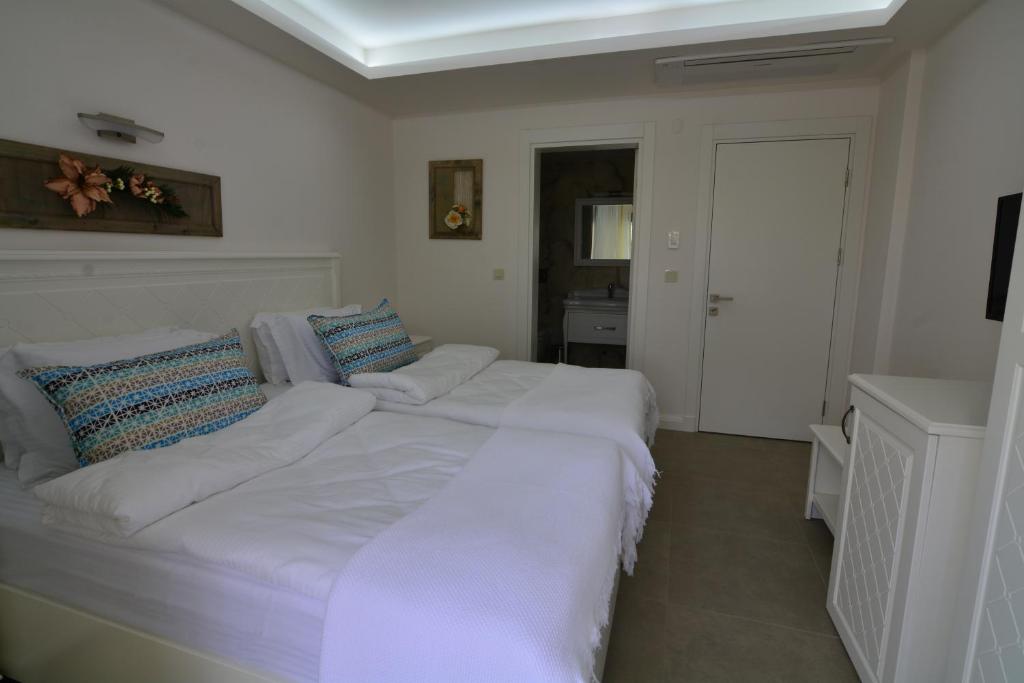 a large white bed with pillows in a bedroom at Dalyan Risus Suite in Çeşme