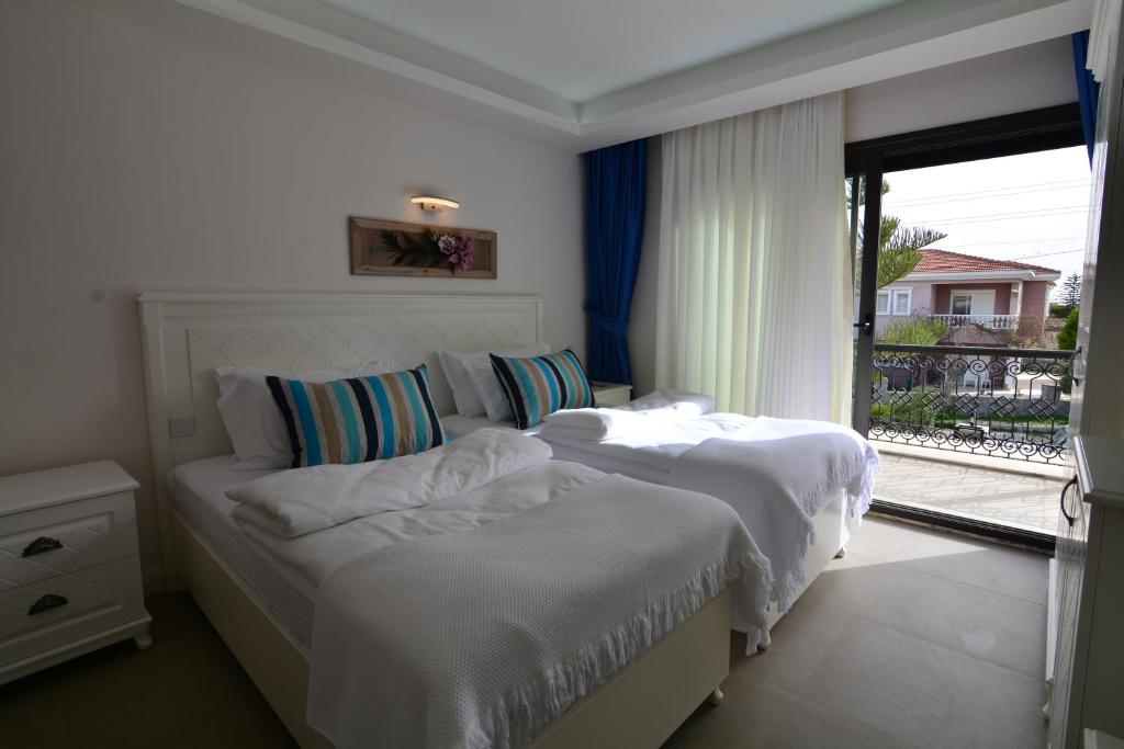 a bedroom with two beds and a window with a view at Dalyan Risus Suite in Çeşme