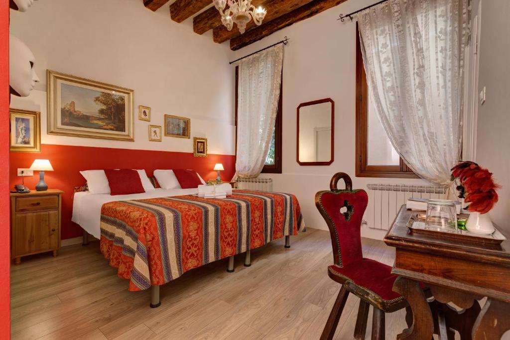 a bedroom with a bed and a table and a desk at Hotel San Samuele in Venice