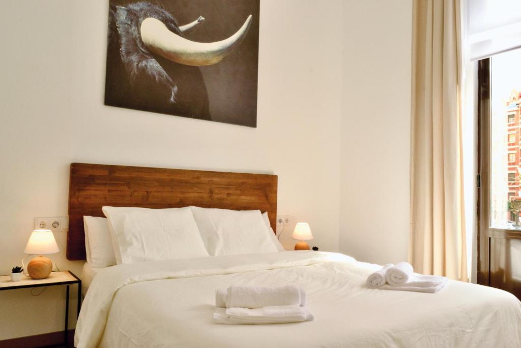 バレンシアにあるHola Valencia - Holiday Apartmentsのベッドルーム1室(大きな白いベッド1台、タオル付)