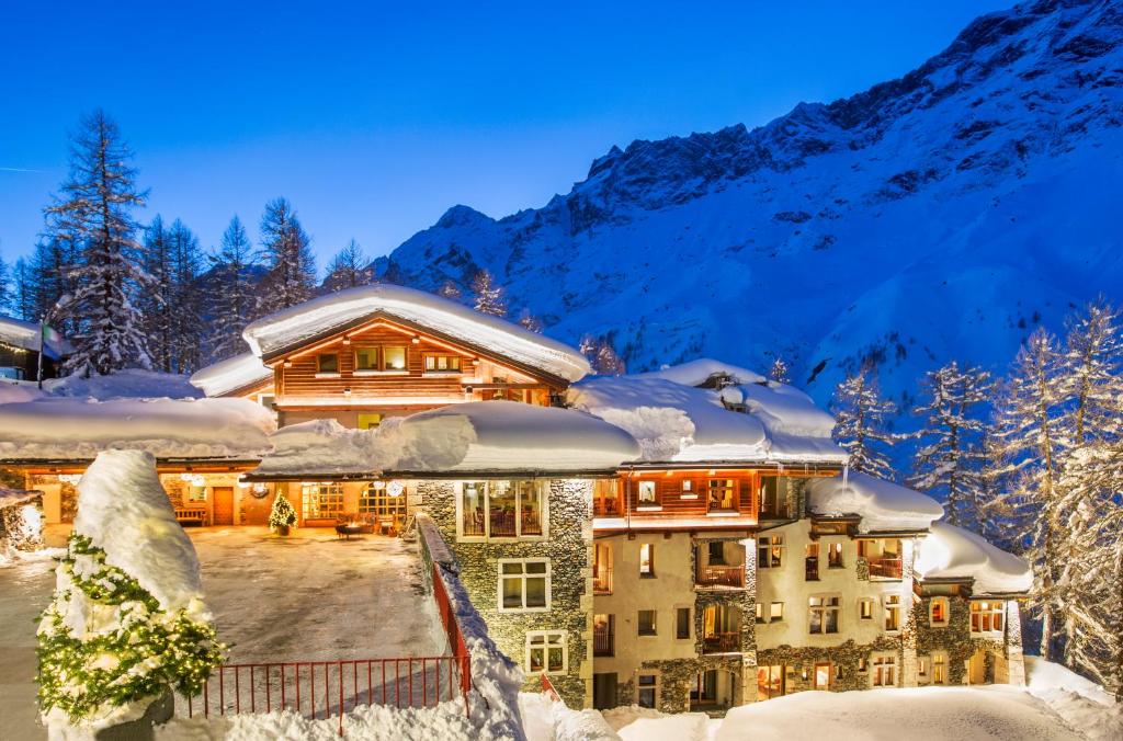 a house covered in snow in the mountains at Saint Hubertus Resort in Breuil-Cervinia