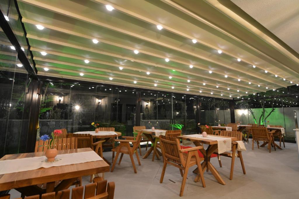 a restaurant with wooden tables and chairs and lights at Dalyan Risus Suite in Çeşme