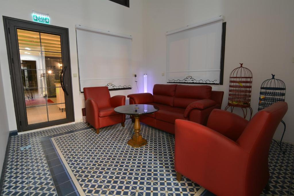 a living room with red couches and a table at Dalyan Risus Suite in Çeşme