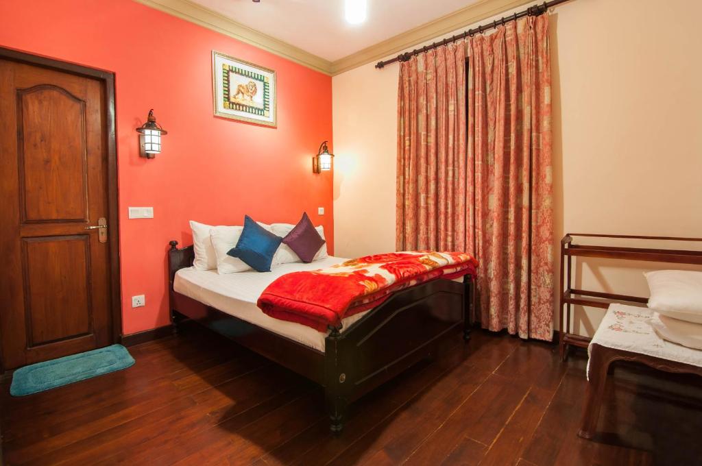 una camera da letto con un letto con pareti rosse e una finestra di Royal Wattles a Nuwara Eliya