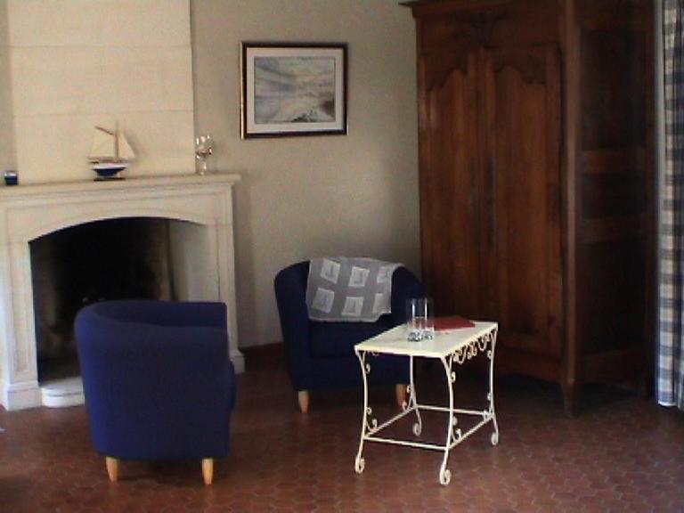 un salon avec une chaise bleue et une table dans l'établissement L'eau vive, à Amblie