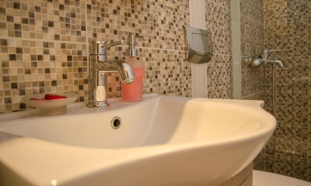 a white sink with a soap dispenser on top of it at Lakki Village in Aegiali