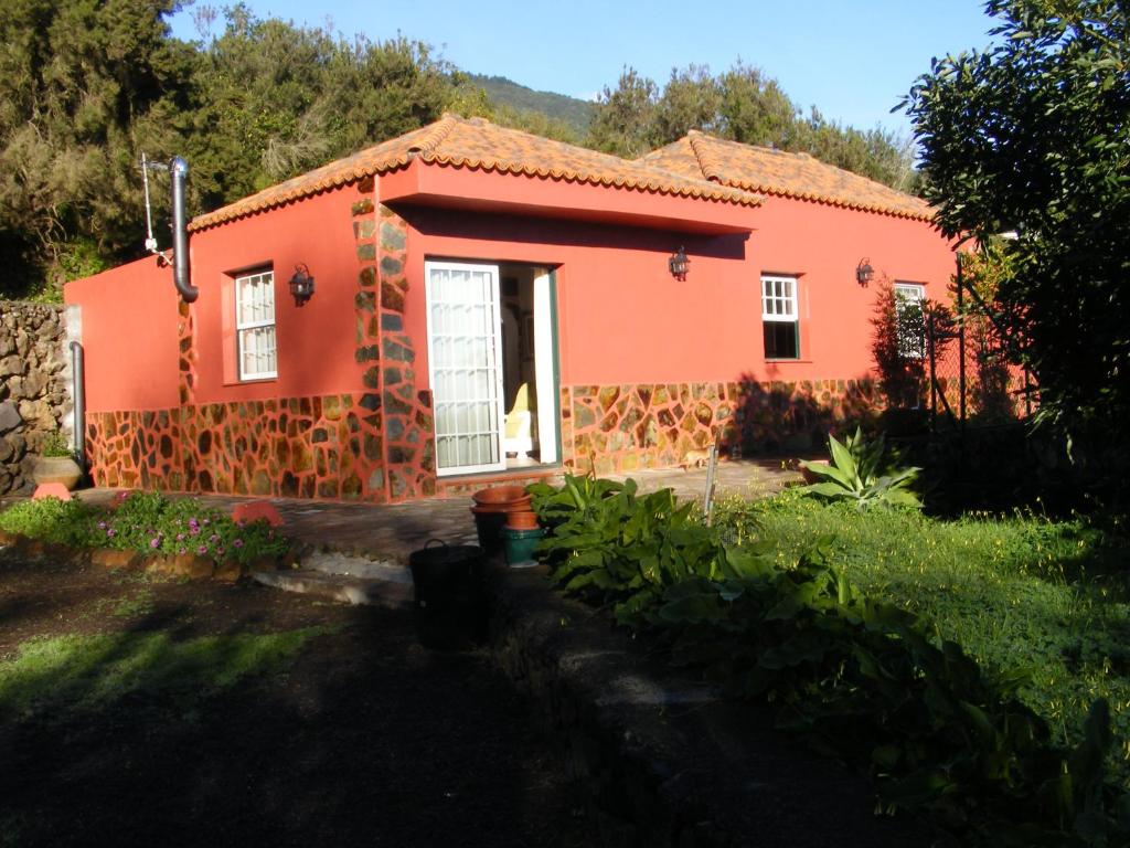 a small orange house in the middle of a yard at Casa Heydi in Breña Alta