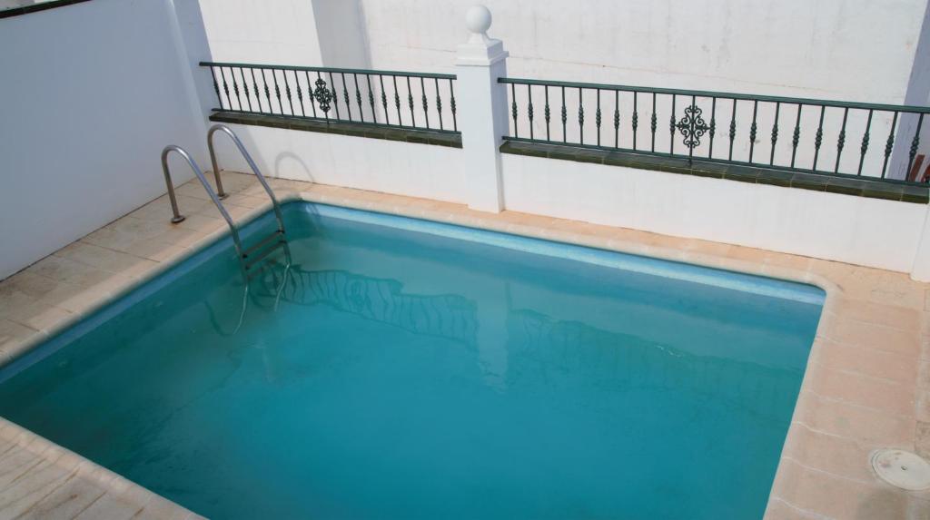 a large blue swimming pool with a balcony at Easy Nerja Apartments in Nerja