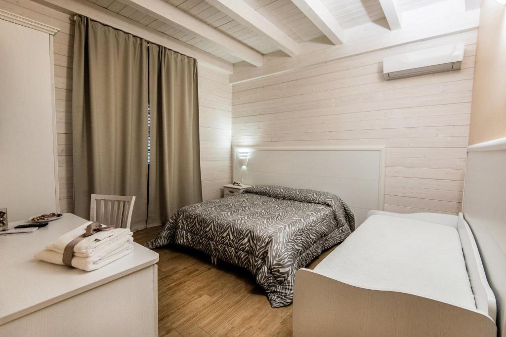 Habitación pequeña con cama y escritorio. en Le Camelie en Ginosa Marina