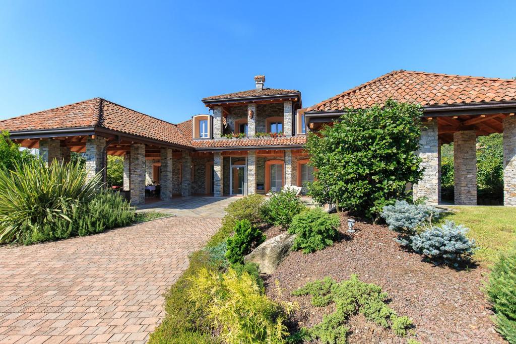 une grande maison avec une allée en briques dans l'établissement Villa Il Grotto, à Verbania