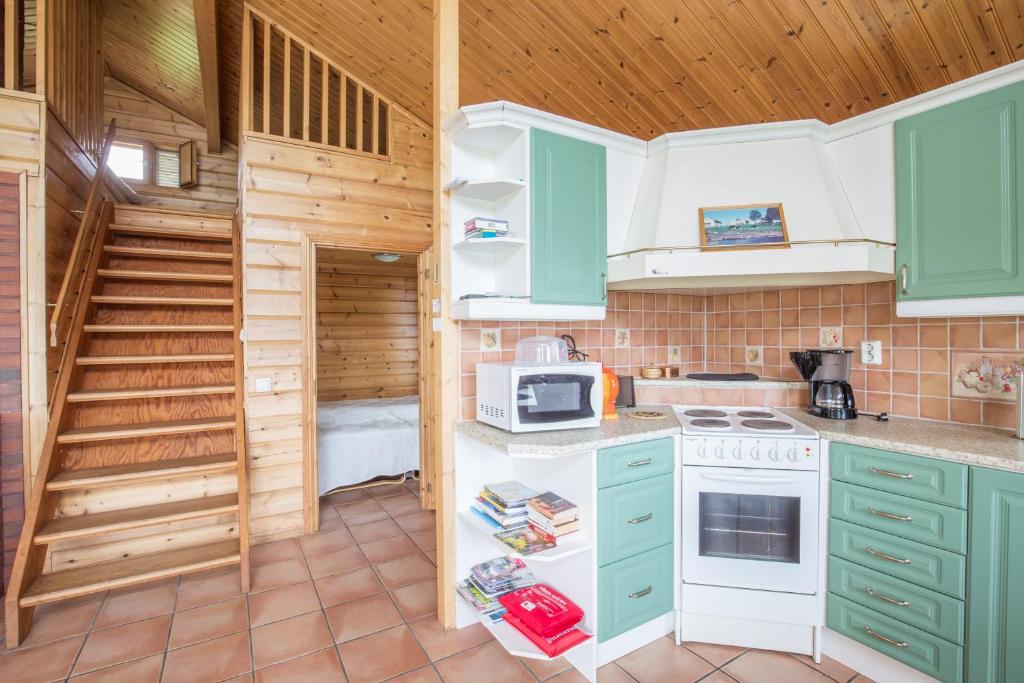 a kitchen with green cabinets and a white stove top oven at Nivagården in Korpikylä