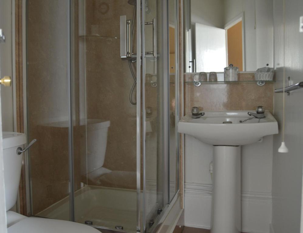 a bathroom with a glass shower and a sink at A-Haven Townhouse Hotel in Edinburgh