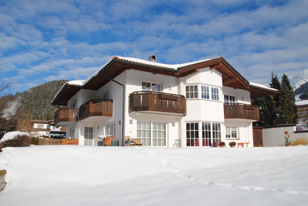 Casa blanca con balcón en la nieve en Appartement am Sonnweg, en Seefeld in Tirol