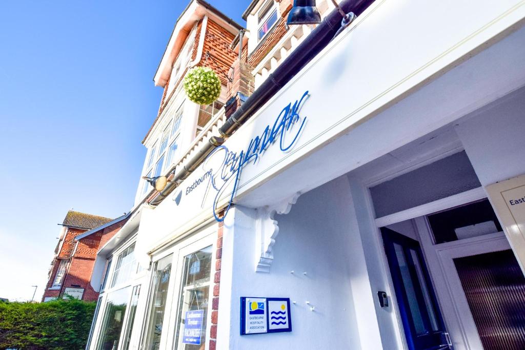 a white building with a sign on the side of it at Eastbourne Reymar in Eastbourne