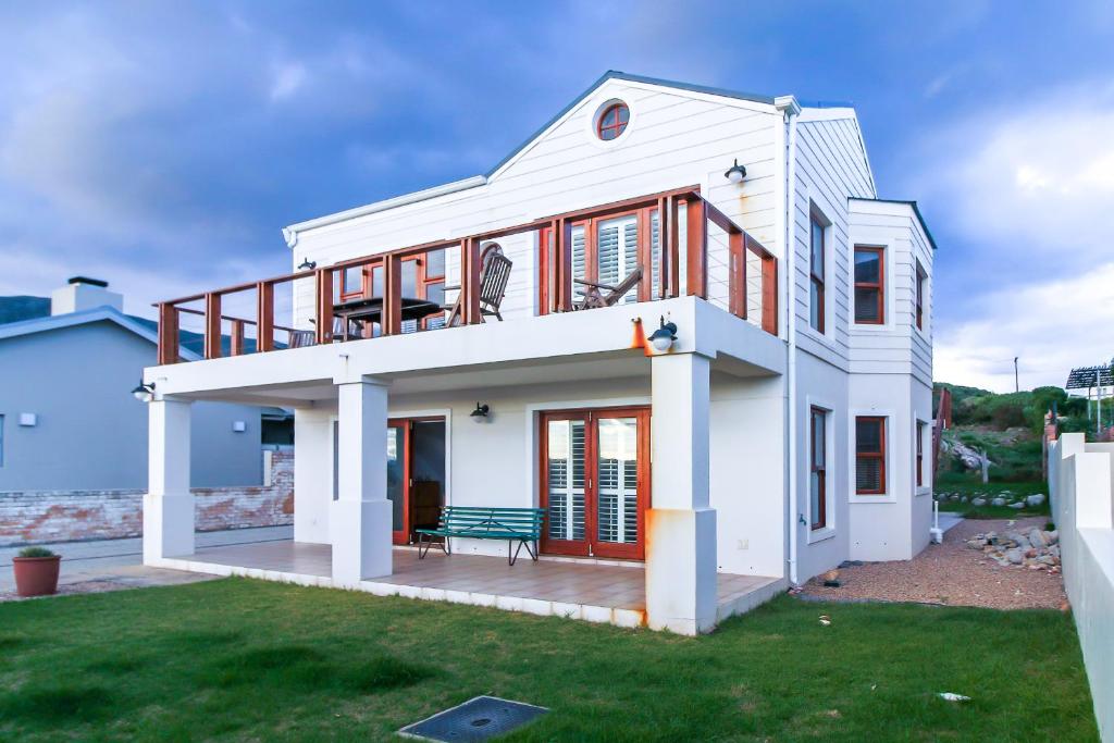 ein weißes Haus mit einer Bank auf einem Hof in der Unterkunft Geheim Luxury Seafront in Hermanus