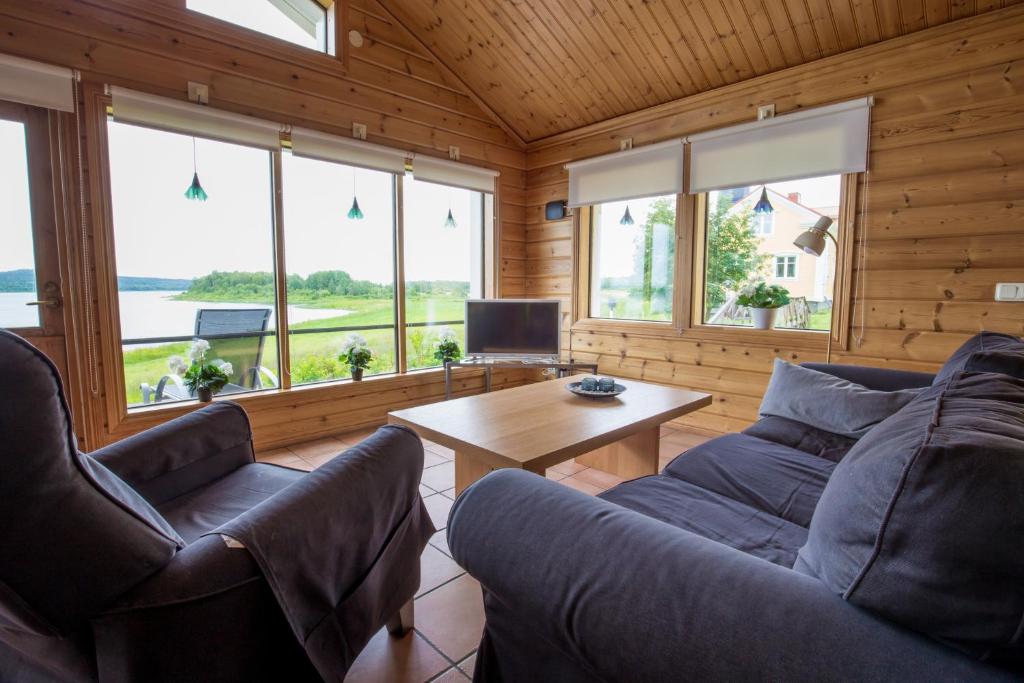 a living room with two couches and a table at Nivagården in Korpikylä