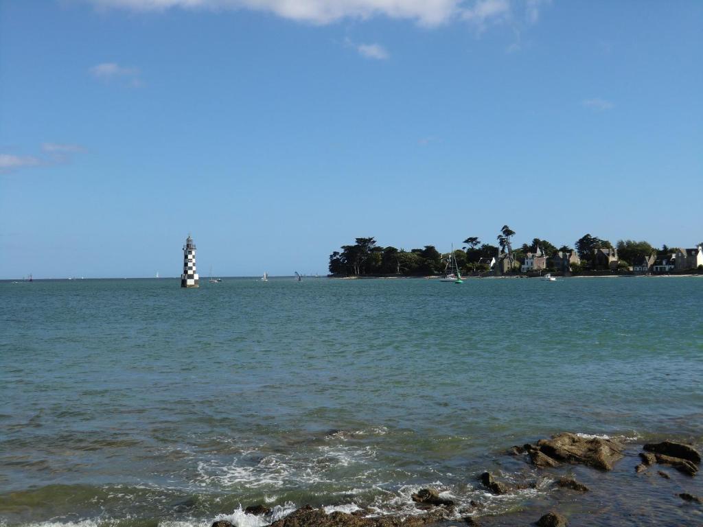 ein Leuchtturm in der Mitte eines Wasserkörpers in der Unterkunft à 50 mètres de la plage in Île-Tudy