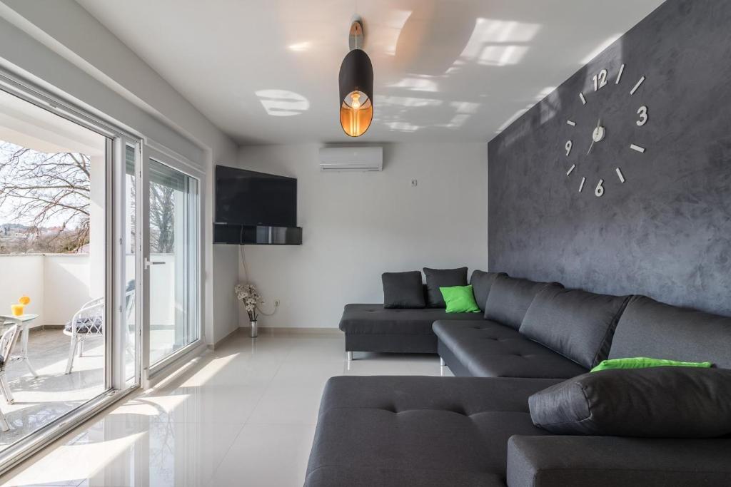 Una sala de estar con un sofá y un televisor. en Apartments Mira, en Pula