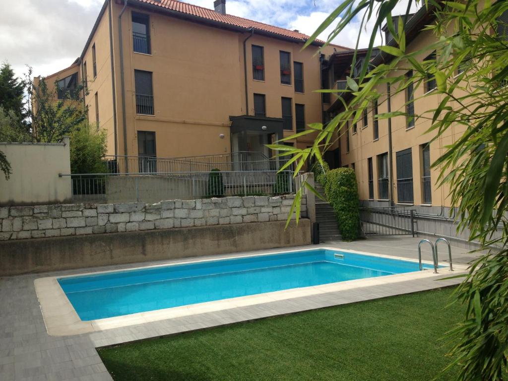 a swimming pool in a yard next to a building at Fuensaldaña Turística in Fuensaldaña