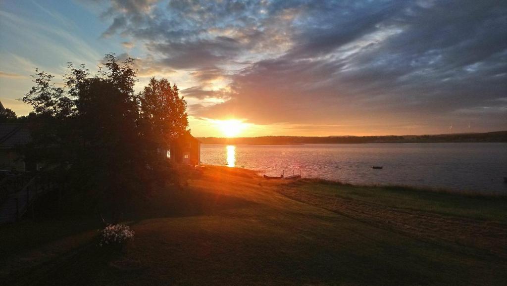a sunset over a lake with the sun setting at Nivagården in Korpikylä