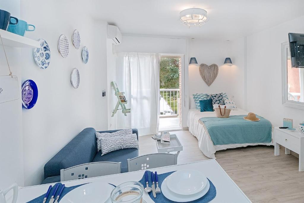 ベナルマデナにあるCozy Flat Simona Costa del Solの白いリビングルーム(青いソファ、ベッド付)