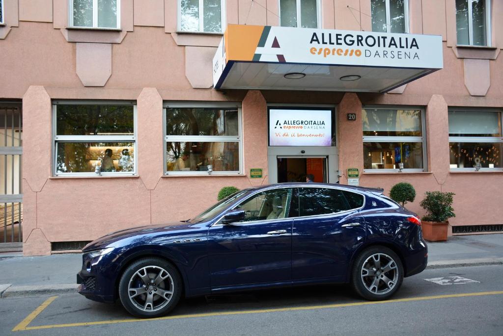 un coche azul estacionado frente a una tienda en Allegroitalia Espresso Darsena, en Milán