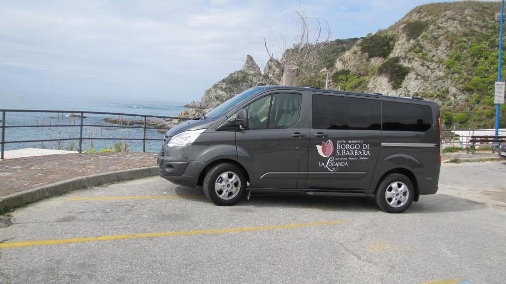 a van parked in a parking lot near the ocean at Borgo di Santa Barbara in Santa Domenica