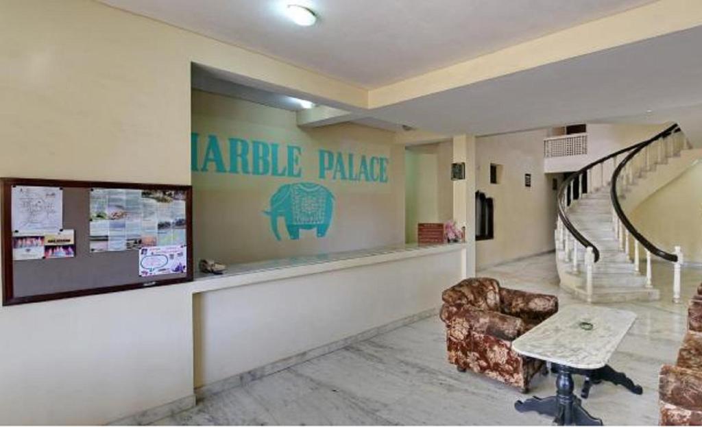 ein Wartezimmer mit einem Stuhl und einer Treppe in der Unterkunft Hotel Marble Palace in Khajurāho