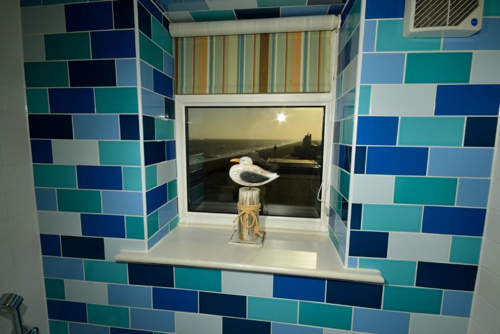 a bathroom with a window with a bird in it at The Brudenell in Aldeburgh