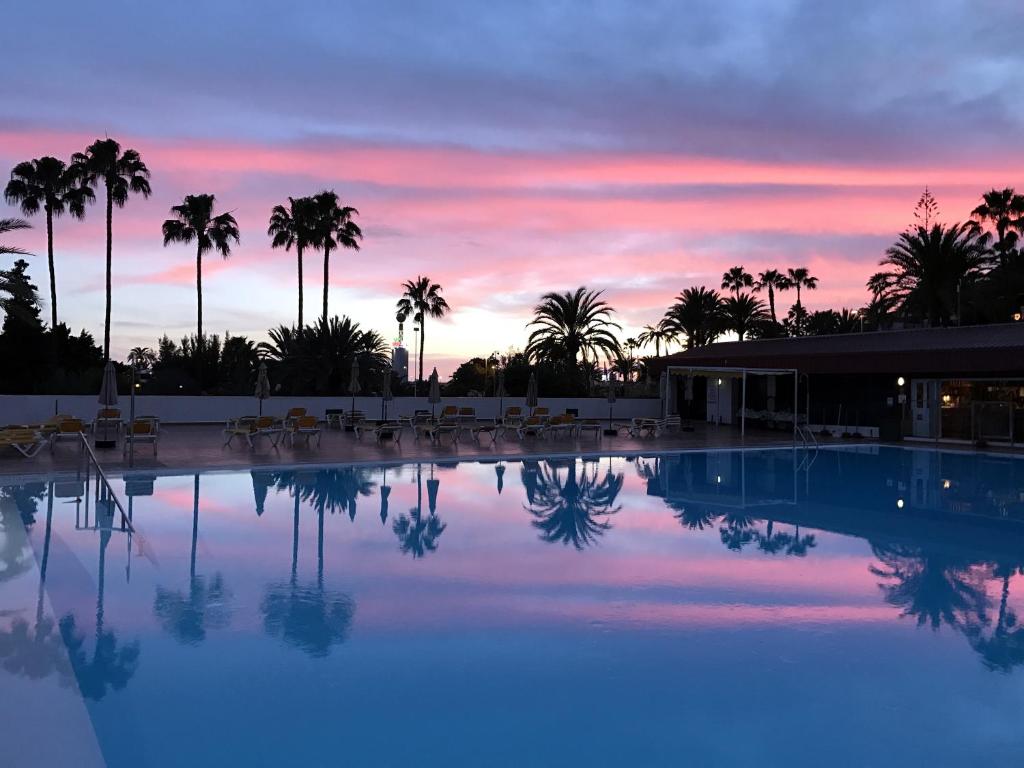 サンアグスティンにあるSan Agustin sea viewのヤシの木と夕日を望むスイミングプール