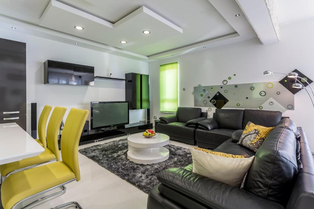ein Wohnzimmer mit einem Sofa und einem TV in der Unterkunft Sea Pearl Luxury Apartment in Strožanac