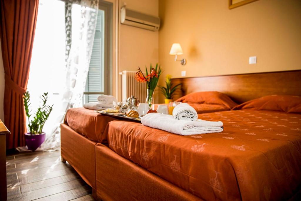 a hotel room with two beds with towels on the bed at Togias Hotel in Egina