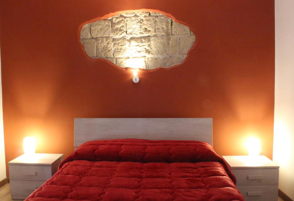 a bedroom with a red bed with two lights at Napoli Central Gate in Naples