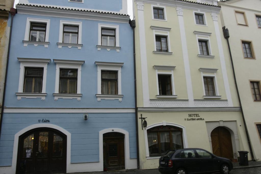 un edificio azul junto a dos edificios blancos en Hotel U Zlateho Andela, en Pardubice