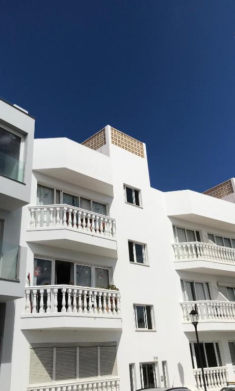 Biały budynek z balkonami na boku w obiekcie Vivienda Vacacional Maga w Corralejo