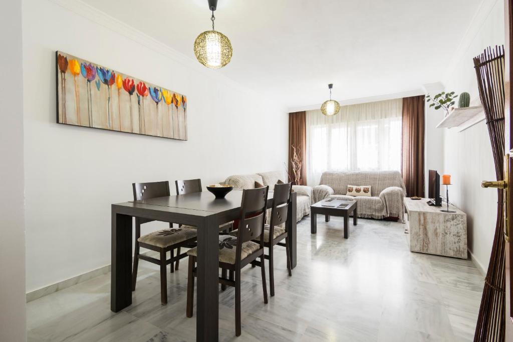 comedor con mesa negra y sillas en Apartamento Alaska 800 m de la Playa Parking Privado, en Málaga