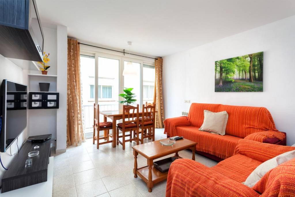 a living room with an orange couch and a table at Maison Lamic 2 in Lloret de Mar