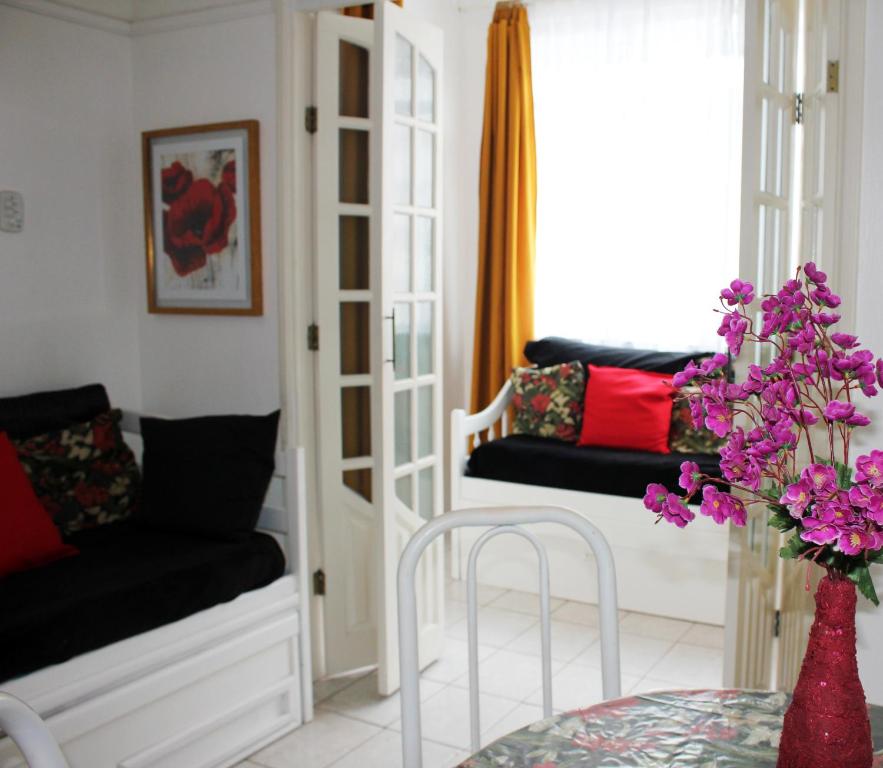 sala de estar con sofá y mesa con flores púrpuras en LINDO E BARATO, AV COPACABANA 1032, en Río de Janeiro