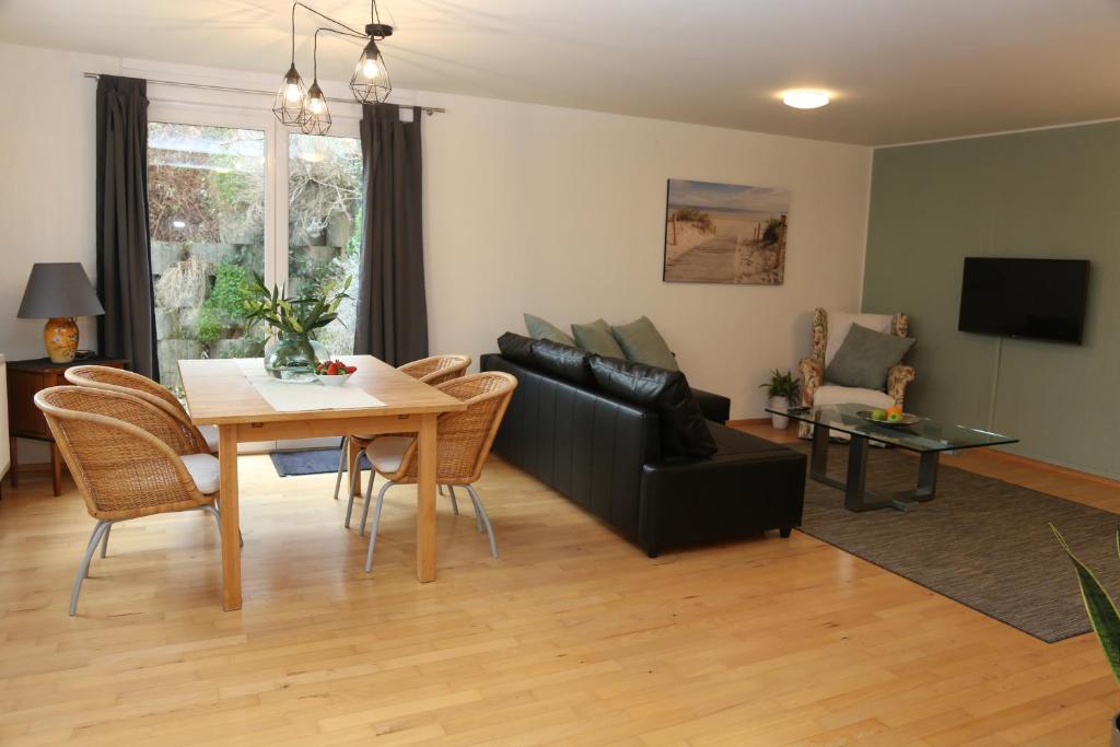 ein Wohnzimmer mit einem schwarzen Sofa und einem Tisch in der Unterkunft KAntryside in Karlsruhe