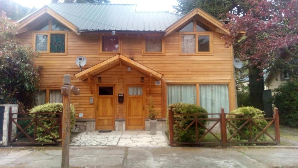 una casa de madera con una puerta delante de ella en Departamentos Sonne Depto Planta Alta en San Martín de los Andes