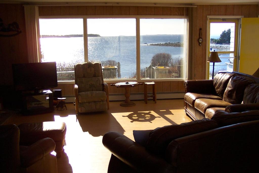 a living room with couches and a large window at C-Scape in Boutiliers Point