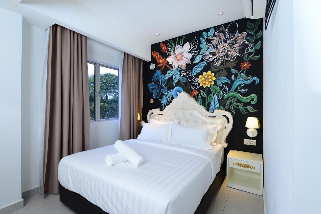 a bedroom with a white bed with a floral wall at Hotel de Art USJ 21 in Subang Jaya