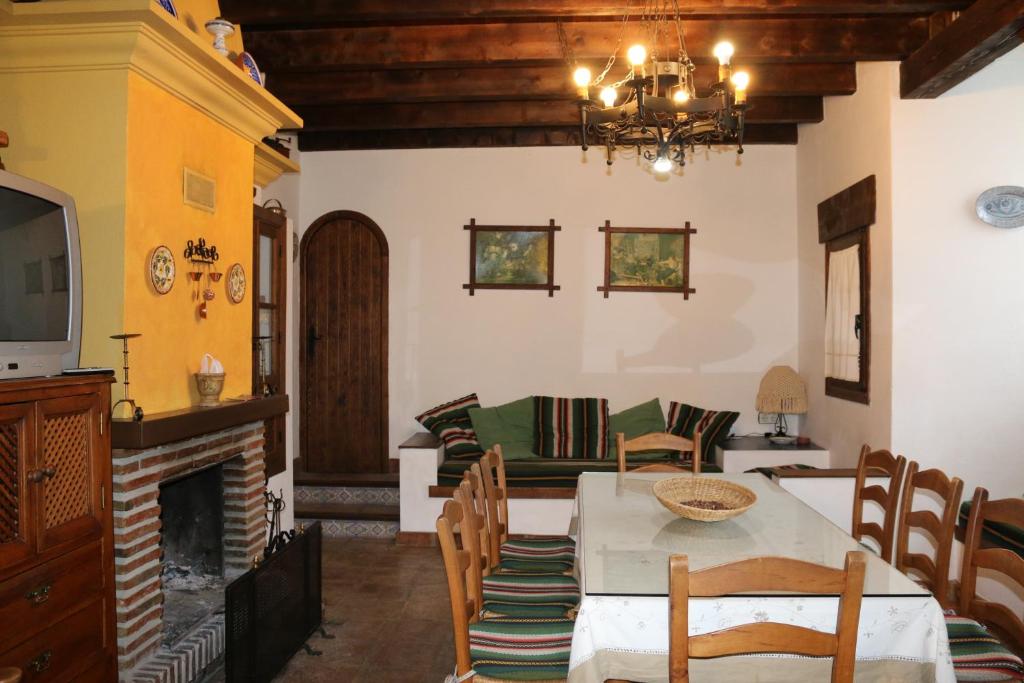 a living room with a table and chairs and a fireplace at Casa Huerta San Francisco in Casarabonela