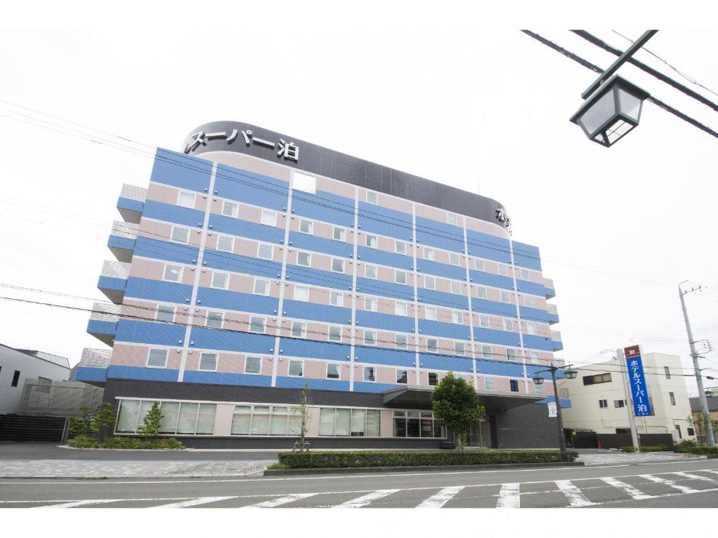 a blue building with a sign on top of it at Hotel Super Tomari in Fujieda