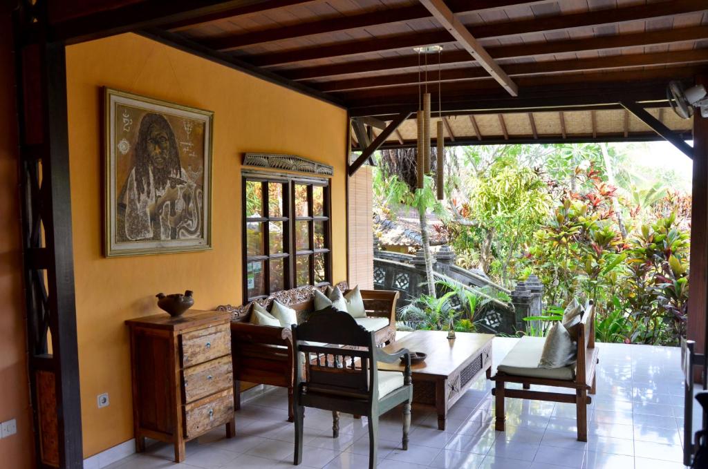 - un salon avec un canapé, une table et des chaises dans l'établissement Guci Guesthouses, à Ubud